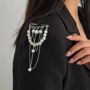 Elegante Brosche mit Kunstperlen und silbernen Kettenanhängern an einem schwarzen Blazer-Detail