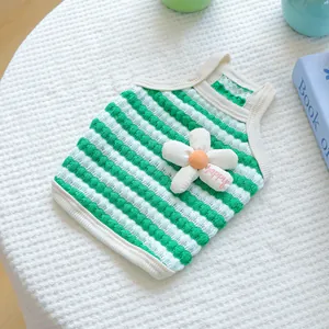 Detailed macro shot of a green and white striped pet vest featuring a cute fabric flower