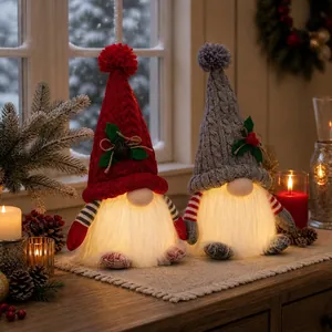 Detail shot of two warm glowing Christmas LED gnomes with festive knitted hats.