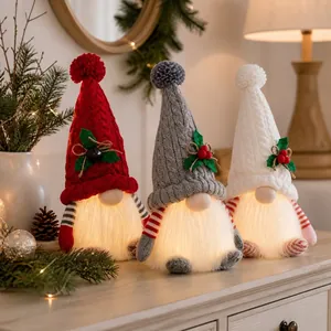 Three glowing Christmas gnomes with knitted hats for festive indoor decoration