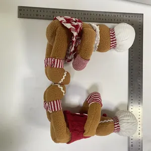 Detailed view of Christmas gingerbread man plush wine bottle decorations with metal ruler