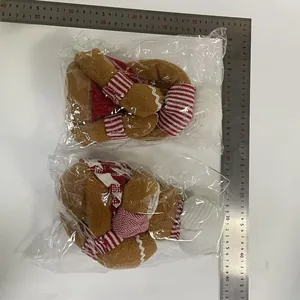 Two Christmas gingerbread man wine bottle decorations in plastic packaging with measurement ruler.