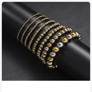 Primo piano di braccialetti con perline in acciaio inossidabile color oro e argento