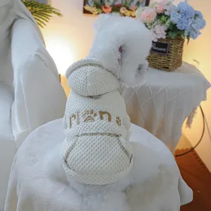 Close-up of white waffle-knit pet hoodie with embroidered paw print and D-ring