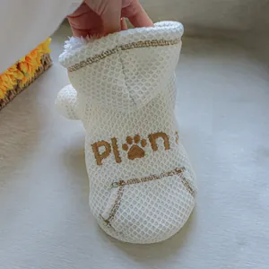 Close-up detail of a white waffle-knit pet hoodie with fleece lining and paw embroidery
