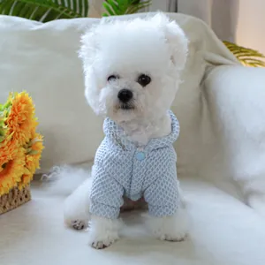 Macro detail of blue quilted pet hoodie showing warm fabric texture and hood on a white dog