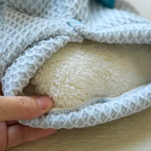 Close-up view of the soft white fleece lining on a blue patterned dog hoodie sweater.
