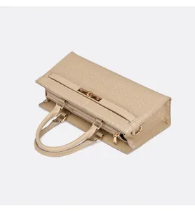 Vue de dessus d'un sac à main beige tressé avec fermoir tournant doré élégant.