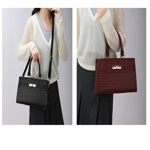 Sac à main élégant à texture tissée noire et bordeaux avec fermoir métallique.
