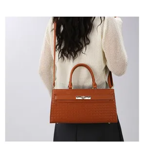 Vue détaillée d'un sac à main marron à texture tressée porté par un mannequin de dos