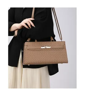Vue détaillée d'un sac à main marron à texture tressée avec fermoir en métal doré.