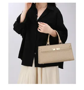 Sac à main élégant beige avec texture tressée et détails dorés porté par modèle