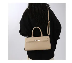 Vue arrière d'un modèle portant un sac à main beige à texture tissée et fermoir en métal