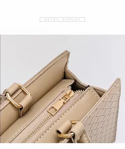 Vue macro détaillée montrant la fermeture éclair dorée et la texture du cuir tressé beige