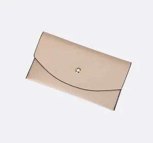 Vue détaillée d'une pochette en cuir grainé beige avec un fermoir à bouton-pression doré.