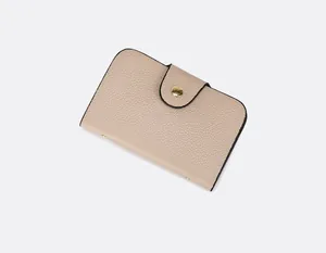 Vue rapprochée d'un portefeuille beige en cuir grainé avec bouton pression doré
