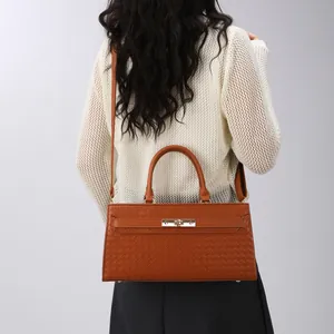 Sac à main élégant pour femme avec texture tressée marron, fermeture en métal et bandoulière.