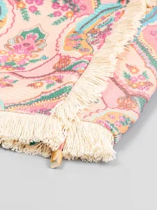 Gros plan d'un sac cabas en toile rétro bohème avec imprimé floral et franges de couleur crème.