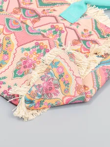 Détail d'un sac cabas en toile à fleurs de style bohème avec franges et anses turquoise