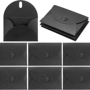 Detailed view of multiple black pearl paper envelopes featuring heart-shaped buckle closures