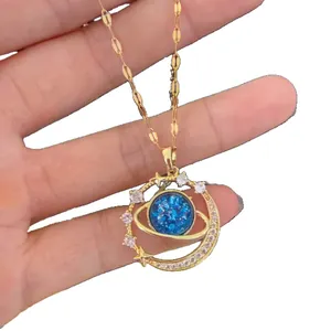 Collana con pendente pianeta stellato scintillante dorato con centro blu e luna