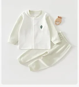 Gros plan d'un ensemble pyjama pour bébé en coton crème avec broderie d'arbre délicate