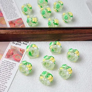 Close-up macro view of hand-painted light green fruit pattern beads for DIY crafts
