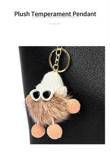 Close-up of a cute furry monster keychain pendant with sunglasses on a black leather bag