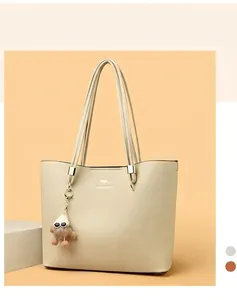Large capacity beige tote bag for women, commuter style with plush charm detail.
