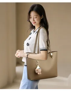 Asian model carrying a large capacity minimalist khaki tote bag for commuter use.