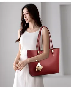 Large red vegan leather commuter tote bag for women with stylish furry charm detail