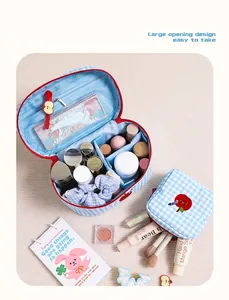 Close-up detail of the checkered makeup bag showing internal storage dividers and apple embroidery