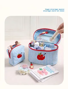 Detailed view of blue checkered makeup bag with internal storage and apple embroidery