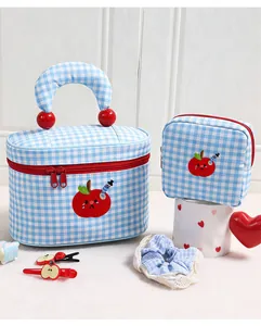 Detailed view of blue checkered cosmetic bag set featuring cute apple embroidery