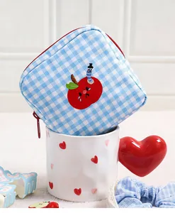 Blue and white gingham makeup bag featuring a cute apple embroidery for travel storage