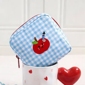 Cute blue and white gingham cosmetic bag with detailed apple and worm embroidery.