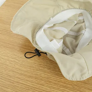 Detalle del interior de un sombrero de sol beige plegable con cordón ajustable y tope