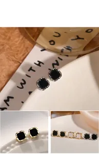 Detailansicht eleganter geometrischer quadratischer Ohrstecker in edlem Schwarz und Weiß.