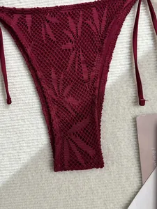 Gros plan détaillé d'un bas de bikini au crochet bordeaux avec motifs de feuilles délicats