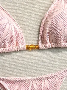 Vue rapprochée d'un ensemble bikini sexy en dentelle florale rose avec perles ambrées