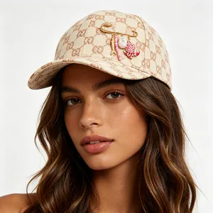 Close-up of ocean-themed charm pin on a monogrammed beige baseball cap