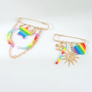 Detail view of vibrant rainbow safety pin brooches with star, sun, and heart charms