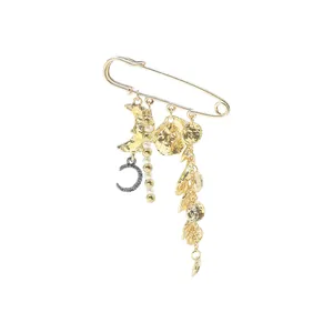 Detailed close-up of a gold celestial brooch pin featuring moon and pearl charms
