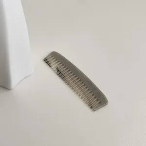 Elegant mini acetate wide-tooth comb featuring a grey marble pattern for portable hair care