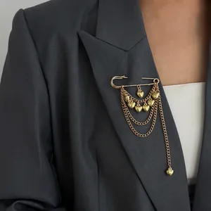 Close-up detail of a fashion gold safety pin brooch with hanging hearts on a dark suit