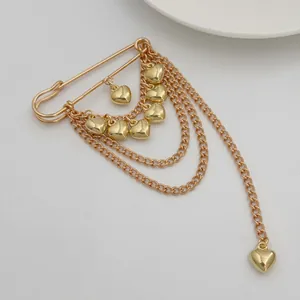 Elegant gold safety pin brooch featuring layered chains and multiple heart-shaped pendants