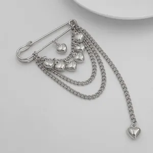 Detailed macro view of a silver heart pendant brooch with elegant layered chain design