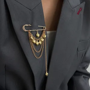 Elegant gold safety pin brooch with layered chains and heart pendants for blazer