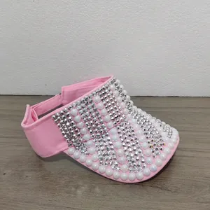 Detailaufnahme des rosa Sonnenvisiers mit funkelnden Strasssteinen und Perlenstickerei