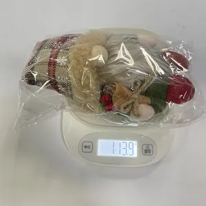 Weight measurement showing 113.9g for this vintage plaid Christmas gnome plush figurine.